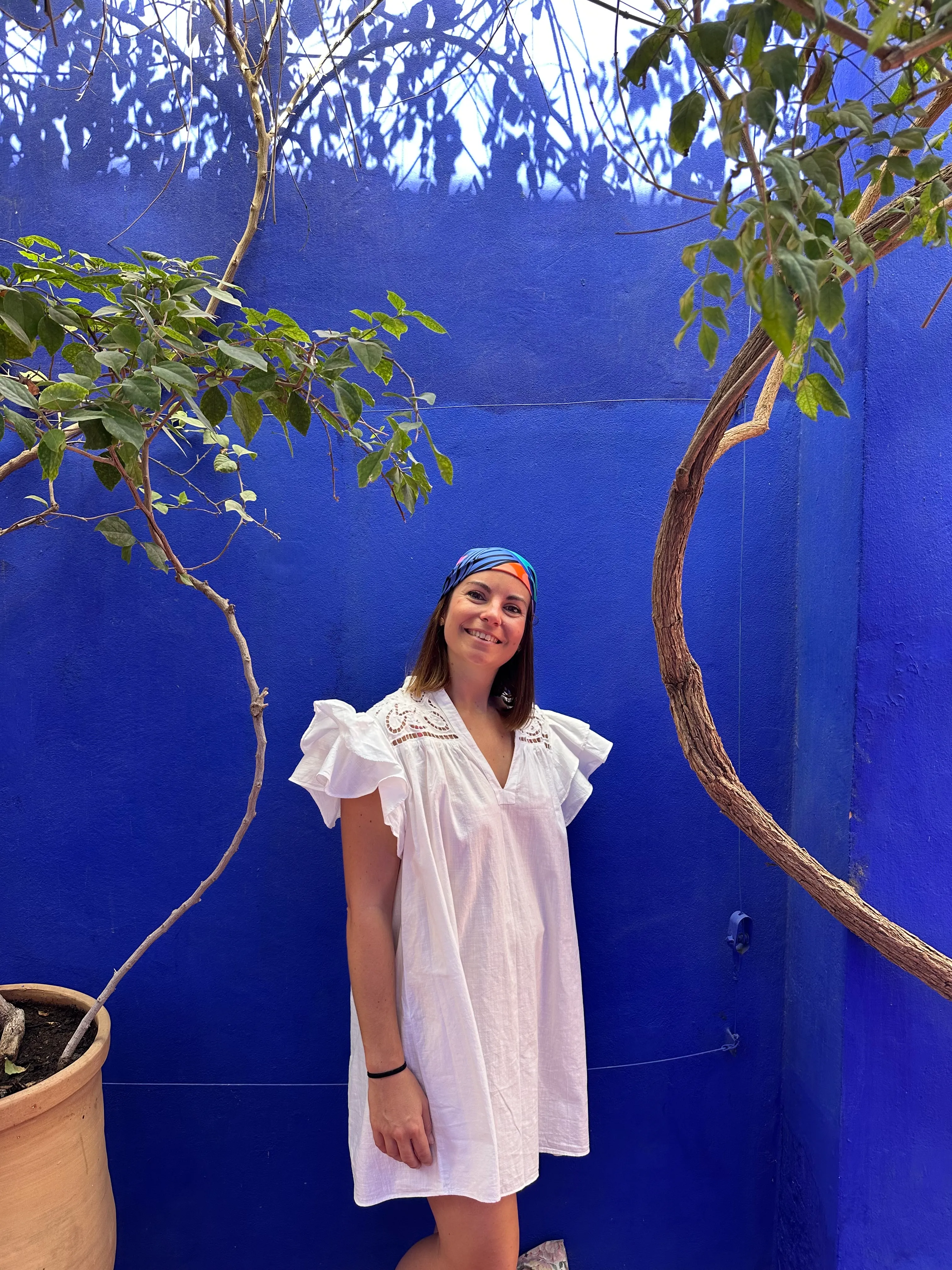 Portrait professionnel devant un mur bleu, illustrant l’univers raffiné et humain de Fitzroy Voyages, créateur de voyages sur mesure haut de gamme.