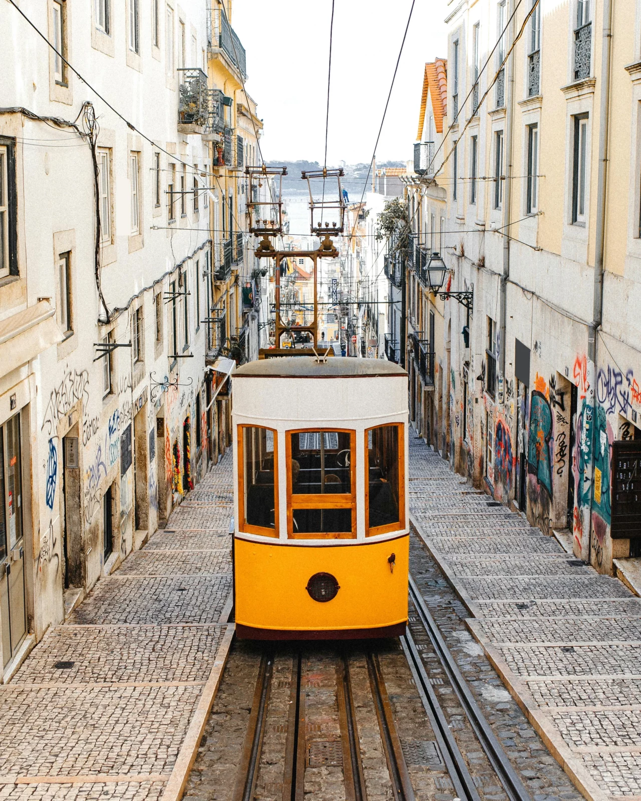 Tramway jaune dans une rue pavée, illustrant un voyage sur mesure haut de gamme au cœur des villes iconiques